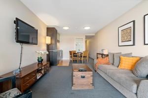 a living room with a couch and a tv at THE BEACON - 2 BEDROOM TOWN CENTER APARTMENT 614 in Queenstown
