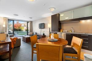 a kitchen and living room with a table and chairs at THE BEACON - 2 BEDROOM TOWN CENTER APARTMENT 614 in Queenstown