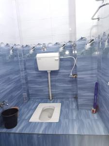 AyodhyaにあるAaditya Palaceの青いタイル張りの客室で、バスルーム(トイレ付)が備わります。