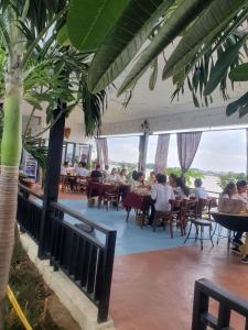 a group of people sitting at tables in a restaurant at Koh Dach View Boutique Hotel in Phnom Penh