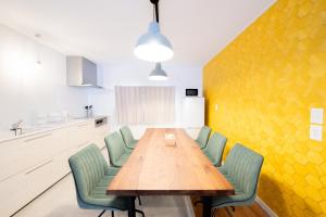 富良野的住宿－Powder Chalet Furano - Vacation STAY 27375v，一间带木桌和绿色椅子的用餐室