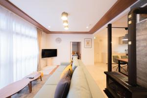 a living room with a couch and a tv at Powder Chalet Furano - Vacation STAY 27375v in Furano