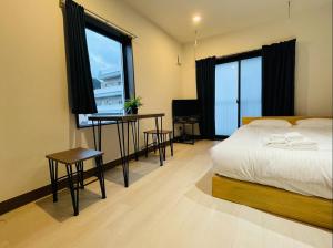 a bedroom with a bed and two tables and two windows at self-check in-押上 Tokyo Skytree in Tokyo