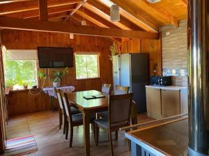 a kitchen and dining room with a table and a refrigerator at Vista verde Llonquén in Liquiñe
