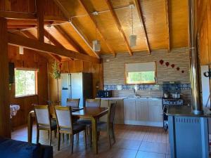 a kitchen and dining room with a table and chairs at Vista verde Llonquén in Liquiñe