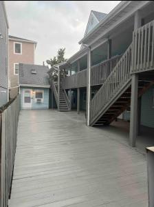 a house with a wooden deck with stairs on it at Ocean Block Oasis, 2-Bed Condo in Seaside Heights
