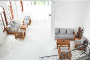 sala de estar con sofás y sillas en De Luna Guest House, en Kuripan