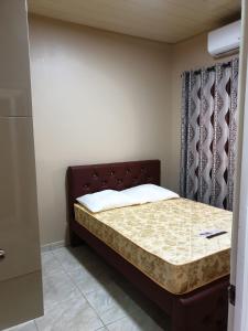 a small bedroom with a bed with a headboard at Rowsu 3 in Wanica