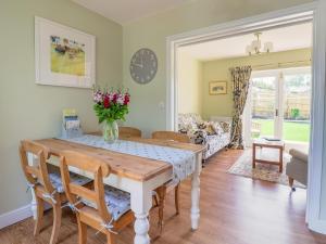 a dining room with a table with flowers on it at Questant Lodge in Sidmouth +7 photos
