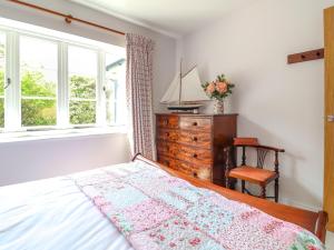 a bedroom with a bed and a dresser and a window at Questant Lodge in Sidmouth