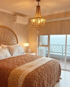 a bedroom with a large bed and a chandelier at Chic Bohemian Hideaway in Umdloti