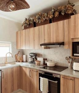 a kitchen with wooden cabinets and a stove top oven at Chic Bohemian Hideaway in Umdloti +12 photos