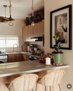 a kitchen with a counter with two chairs and a plant at Chic Bohemian Hideaway in Umdloti