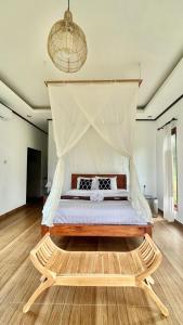 a bedroom with a bed with a canopy at Papahan Bali in Sidemen