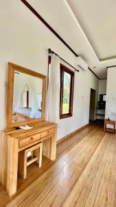 um quarto com um espelho e uma mesa de madeira em Papahan Bali em Sidemen
