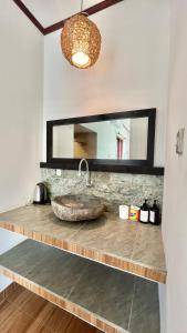 uma casa de banho com um lavatório de pedra e um espelho. em Papahan Bali em Sidemen