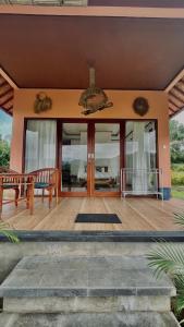 um alpendre frontal de uma casa com portas de vidro em Papahan Bali em Sidemen