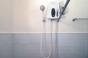 a bathroom with a blow dryer in a shower at Jessa's 5 Guests house in Moalboal