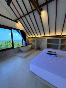 a bedroom with a bed and a tub and windows at Divinity Villas - Uluwatu, Bali in Uluwatu