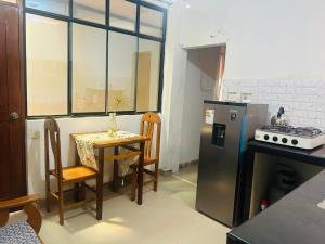 uma pequena cozinha com uma mesa e um frigorífico em Mini depa de una habitación em Pucallpa