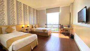a hotel room with two beds and a window at Hotel 88 Embong Malang Surabaya By WH in Surabaya