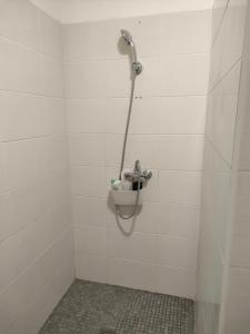 una ducha en un baño de azulejos blancos en Chambre cosy, en Viry-Noureuil 5 fotos más