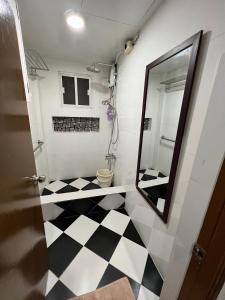 La salle de bains est pourvue d'un miroir et d'un sol en damier noir et blanc. dans l'établissement SSC Transient House & Staycation - Imus, à Imus