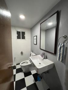 La salle de bains est pourvue d'un lavabo, de toilettes et d'un miroir. dans l'établissement SSC Transient House & Staycation - Imus, à Imus