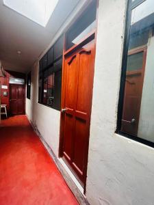 an empty hallway with wooden doors and windows at Mini depa de una habitación in Pucallpa