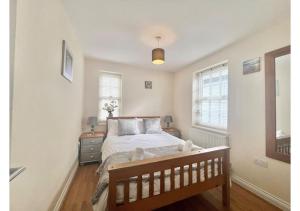 ブリクサムにある1 Captain's Rest Modern 2 bedroom Brixham harbour flatのベッドと2つの窓がある寝室