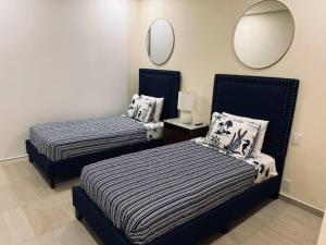 Un dormitorio con dos camas y un espejo. en Luxurious First-Floor Apartment in Isla Residences, en Acapulco 11 fotos más