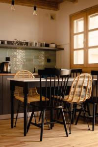 a dining room with a table and chairs in a kitchen at RiW Małe Swory - Domek pływający Houseboat i domki drewniane in Małe Swornegacie