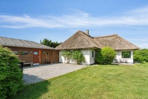 a house with a thatched roof and a yard at Cozy Farmhouse With Fantastic Surroundings, in Farsø