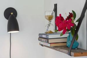 a shelf with books and a clock and a glass of wine at Cozy Farmhouse With Fantastic Surroundings, in Farsø