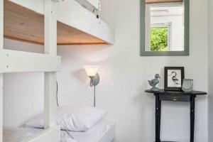 a bedroom with a bunk bed and a mirror at Cozy Farmhouse With Fantastic Surroundings, in Farsø