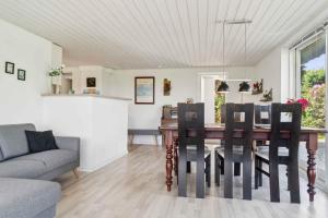 a dining room and living room with a table and chairs at Cozy Farmhouse With Fantastic Surroundings, in Farsø