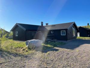 a black house with a fence in front of it at Beautiful cabin close to activities in Trysil, Trysilfjellet, with Sauna, 4 Bedrooms, 2 bathrooms and Wifi in Trysil