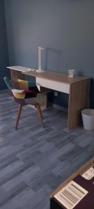 Un escritorio de madera con una silla al lado. en Chambre cosy, en Viry-Noureuil