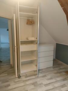 un armario con estanterías blancas y una escalera en Chambre cosy, en Viry-Noureuil