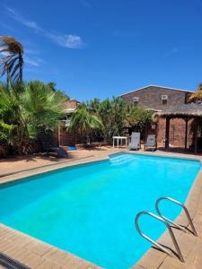 a large blue swimming pool with chairs in a yard at Kalbarri Reef Villa 7 in Kalbarri