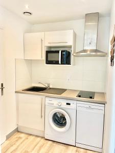 a kitchen with a washing machine and a microwave at ÎLE D OLÉRON Charmante Maison Oléronaise & Piscine chauffée in Saint-Georges-dʼOléron +6 photos
