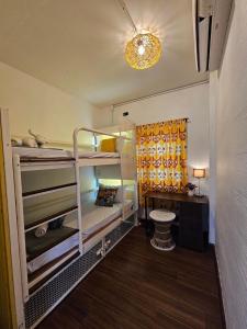 清迈Chiza hostel Chiangmai的客房设有两张双层床和一张书桌。
