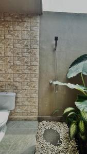 uma casa de banho com um chuveiro, um WC e uma planta em Papahan Bali em Sidemen