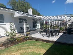 a patio with a table and chairs under a white awning at Cambridge Cottage - Self Catering Holiday House in Cambridge