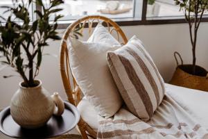 een rotan stoel met kussens erop en een tafel bij 2 Bed In Raha Lofts Hosted By Voyage in Abu Dhabi