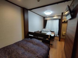 um pequeno quarto com uma cama e uma televisão em Kyoto - apartment / Vacation STAY 168 em Quioto