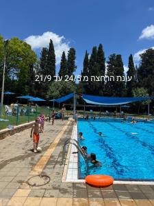 a swimming pool with people in the water at דירת מסע בגליל in Bet Leẖem HaGelilit