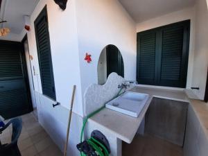 un baño con lavabo y espejo en LaCasaDeiGechiOtranto, en Casamassella