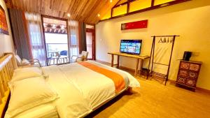 麦田间民宿Terrace View Hotel في لونغشينغ: غرفة نوم فيها سرير وتلفزيون