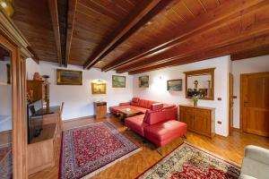 salon z czerwoną kanapą i stołem w obiekcie Hotel El Greco w mieście Rožnov pod Radhoštěm